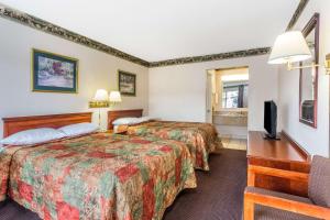 A bed or beds in a room at Days Inn by Wyndham Ashland
