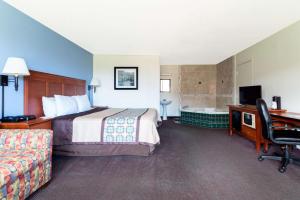 a hotel room with a bed and a desk and a computer at Days Inn by Wyndham Luray Shenandoah in Luray