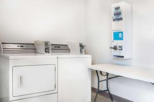 a laundry room with a washing machine and a table at Days Inn by Wyndham San Antonio Interstate Hwy 35 North in San Antonio