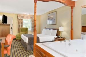 a hotel room with a bed and a bath tub at Days Inn by Wyndham Towson in Towson