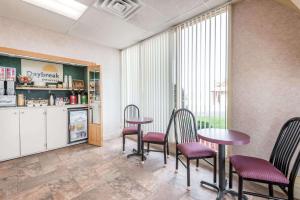 a room with four chairs and a table and a kitchen at Days Inn by Wyndham Niles in Niles