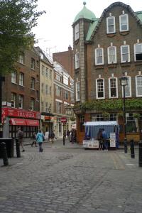 ulica miejska z budynkami i ludźmi chodzącymi po ulicy w obiekcie Stylish apartment near Carnaby Street w Londynie