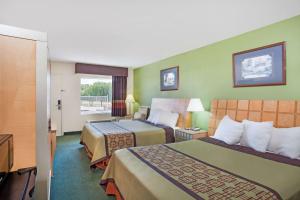 a hotel room with two beds and a window at Days Inn by Wyndham Greeneville in Greeneville