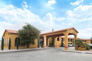 un gran edificio amarillo con aparcamiento en Days Inn by Wyndham Carlsbad, en Carlsbad