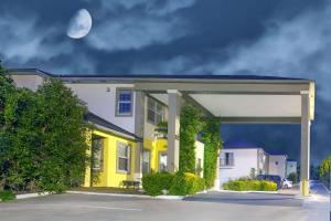 una casa amarilla con una luna en el cielo en Days Inn by Wyndham Suites Fredericksburg, en Fredericksburg