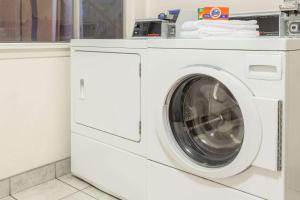 a white washing machine in a white laundry room at Days Inn by Wyndham Modesto in Modesto