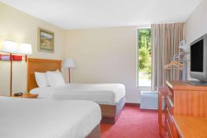 una camera d'albergo con due letti e una televisione di Days Inn by Wyndham Mount Hope a Mount Hope