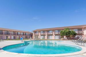 une grande piscine en face d'un bâtiment dans l'établissement Days Inn by Wyndham Modesto, à Modesto