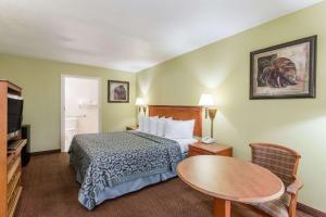 オーモンド・ビーチにあるDays Inn by Wyndham Ormond Beachのベッドとテーブルのあるホテルの部屋