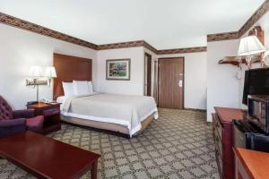 a hotel room with a bed and a tv at Days Inn by Wyndham Dyersburg in Dyersburg