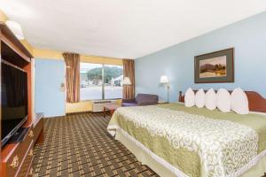 A bed or beds in a room at Days Inn by Wyndham Clayton