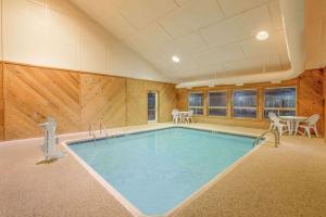 a large swimming pool in a room with wooden walls at Days Inn by Wyndham Worthington in Worthington