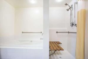 a white bathroom with a tub and a shower at Days Inn by Wyndham Seattle Aurora in Shoreline