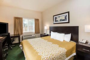 a hotel room with a bed and a television at Days Inn by Wyndham Seattle Aurora in Shoreline