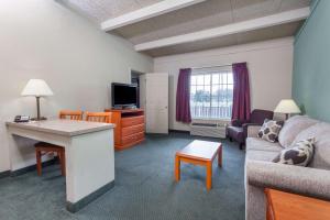 una pequeña sala de estar con sofá y mesa. en Days Inn & Suites by Wyndham Lexington, en Lexington