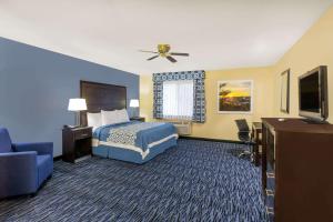 una camera d'albergo con un letto e una TV a schermo piatto di Days Inn by Wyndham Moab a Moab