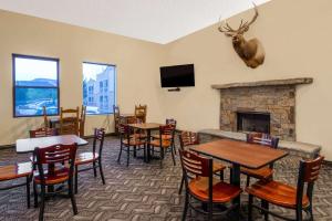 ein Restaurant mit Tischen und Stühlen und einem Kamin in der Unterkunft Days Inn by Wyndham Carbondale in Carbondale