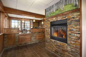 a fireplace in a living room with a brick wall at Days Inn & Suites by Wyndham Gunnison in Gunnison