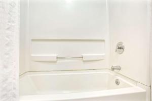 y baño blanco con bañera blanca. en Days Inn by Wyndham Carson City en Carson City