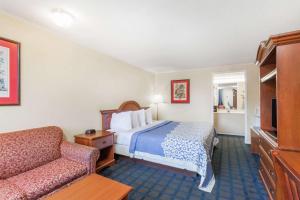 a hotel room with a bed and a couch at Days Inn by Wyndham Dover Downtown in Dover