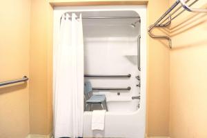 łazienka z zasłoną prysznicową i krzesłem w obiekcie Days Inn by Wyndham Joelton/Nashville w mieście Joelton