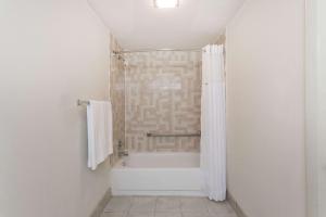 a bathroom with a shower and a bath tub at Days Inn by Wyndham Winston Salem North in Winston-Salem