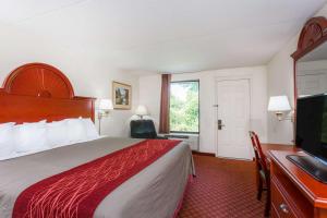 a hotel room with a bed and a flat screen tv at Days Inn by Wyndham Winston Salem North in Winston-Salem