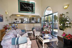 salon z 2 kanapami i stołem w obiekcie Days Inn by Wyndham Riverside Tyler Mall w mieście Riverside