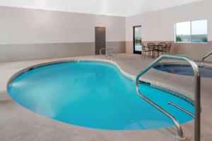 拉斯維加斯的住宿－新墨西哥州拉斯維加斯戴斯酒店，一个带桌椅的房间,有一个蓝色的大游泳池
