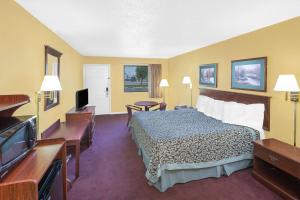 a hotel room with a bed and a flat screen tv at Days Inn by Wyndham N Little Rock East in North Little Rock