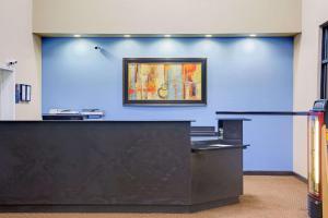 a lobby with a blue wall with a painting on the wall at Days Inn by Wyndham Lawrenceville in Lawrenceville