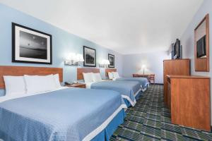 A bed or beds in a room at Days Inn by Wyndham Las Vegas