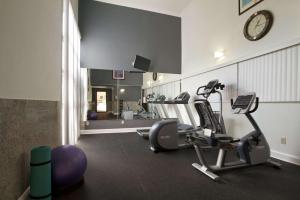 a gym with two exercise bikes and a clock on the wall at Days Inn & Suites by Wyndham Tuscaloosa - Univ. of Alabama in Tuscaloosa