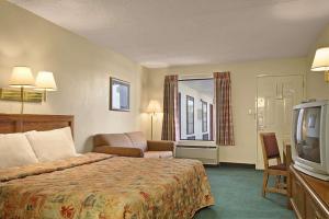 a hotel room with a bed and a television at Days Inn by Wyndham Apple Valley Pigeon Forge/Sevierville in Pigeon Forge