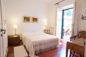 a white bedroom with a bed and a window at B&B Don Gaspano in Milazzo
