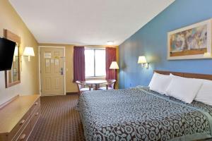 a hotel room with a bed and a table at Days Inn by Wyndham Lawrenceville in Lawrenceville