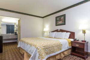 a hotel room with a bed and a bathroom at Days Inn by Wyndham Dickson in Dickson