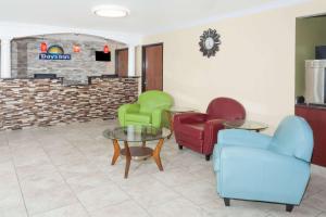 una zona de estar con sillas y mesas en una sala de espera en Days Inn by Wyndham Springfield, en Springfield