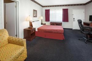 Habitación de hotel con cama, escritorio y silla en Sunset Inn en Costa Mesa