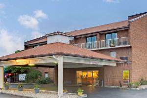 a brick building with a balcony on top of it at Days Inn by Wyndham Cincinnati East in Cherry Grove