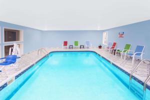 una piscina en una habitación con sillas y mesas en Days Inn by Wyndham Springfield, en Springfield