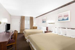 a hotel room with two beds and a desk at Days Inn by Wyndham Kingman West in Kingman