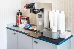 a coffee machine sitting on a counter with paper towels at Days Inn by Wyndham Henrietta/Rochester Area in Henrietta