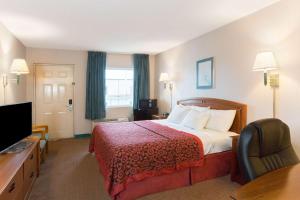 ein Hotelzimmer mit einem Bett und einem Flachbild-TV in der Unterkunft Days Inn by Wyndham Richmond in Richmond