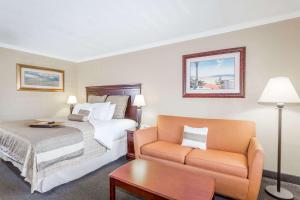 a hotel room with a bed and a couch at Days Inn by Wyndham Destin in Destin