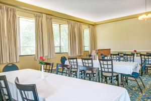 una sala de conferencias con mesas, sillas y ventanas en Days Inn by Wyndham Arlington/Washington DC, en Arlington