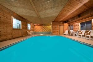 a swimming pool in a house with a wooden ceiling at Days Inn by Wyndham Mankato in Mankato