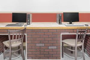 two chairs sitting at a bar with two computer monitors at Days Inn by Wyndham Ruther Glen Kings Dominion Area in Ruther Glen