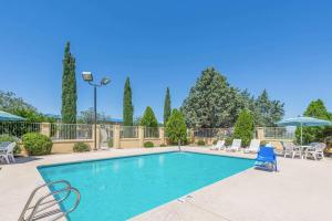una piscina con sillas y sombrillas en Days Inn by Wyndham Deming, en Deming