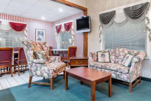 ein Wohnzimmer mit 2 Stühlen und einem TV in der Unterkunft Hamilton Inn Jonesville I-77 in Jonesville